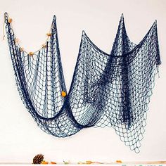 two blue net hanging on the wall next to pine cones and pumpkins in front of it