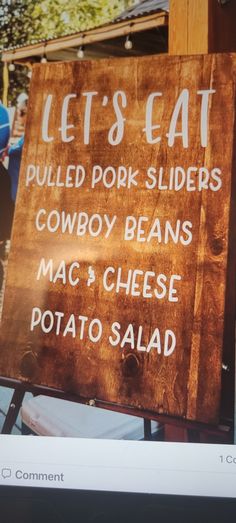 a sign that says let's eat pulled pork sliders cowboy beans mac and cheese potato salad