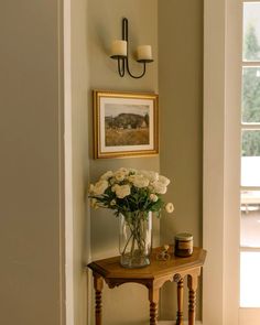 a vase with white flowers sitting on a small table