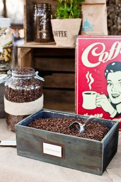 there are coffee beans on the table next to a box with a spoon in it