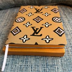 a louis vuitton notebook sitting on top of a couch