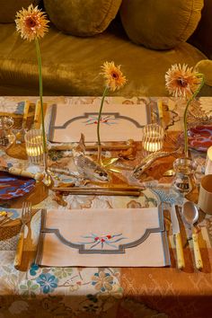 the table is set with silverware and sunflowers