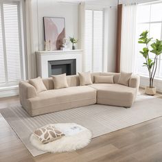 a living room with a large sectional couch and white rug in front of the fireplace