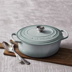 a pot and spoon sitting on top of a wooden board