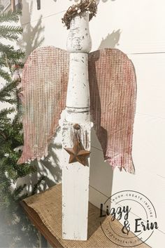 an angel statue on top of a burlock next to a christmas tree branch