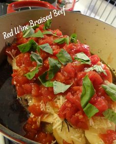 a pan filled with pasta covered in sauce and garnished with fresh basil leaves