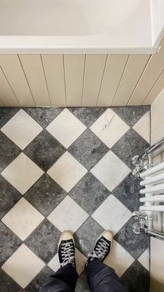 a person standing on a tiled floor next to a radiator