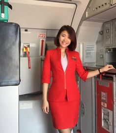 a woman in red is standing on an airplane