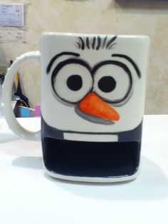 a white and black mug with an angry bird face on it