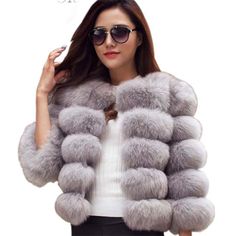 a woman wearing a fur coat and sunglasses