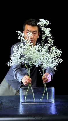 a man holding flowers in front of his face