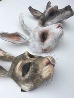 three animal heads are shown on a white surface with paint peeling off the top and bottom