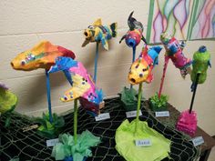 colorful paper mache birds on display in front of a wall