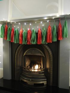 a fireplace decorated with red and green tassels