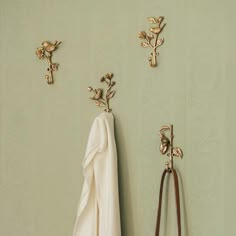 two coats hang on the wall next to a pair of purses and coat hooks