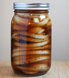 a jar filled with liquid sitting on top of a wooden table