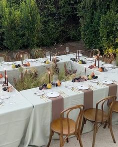 an outdoor dining area with tables and chairs set up for a formal dinner or party