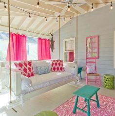 a living room filled with furniture and pink drapes hanging from the ceiling over a white couch