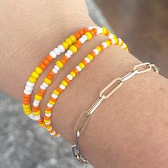 Show some Halloween spirit with these fun Candy Corn bracelets. You can't help but smile when you wear them. I made these using two different size seed beads for added texture.  Mix n match with my other bracelets for endless styles!  You will receive 3 bracelets that are made on strong stretch cord and made to fit a 7 1/2" wrist. Need a different size? Just let me know your wrist size and I will be happy to custom make for you! Each piece is handmade with: - High Quality Glass Seed Beads - Stretch Cord: High-quality cord with reinforced knots Easily layer with other Luna by Rachel bracelets for a stunning stack! My pieces are made sturdy, but as with all jewelry, they are also delicate and should be treated with care. Be sure to check out other designs in my shop at http://etsy.com/shop/l Small Seed Bead Bracelet, Candy Corn Bracelets, Simple Bracelets Diy Beads, Fall Stretch Bracelets, Beaded Bracelets Fall, Fall Seed Bead Bracelets, Seed Bead Bracelet Sets, Halloween Seed Bead Bracelet, Fall Jewelry Diy