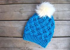 a blue knitted hat with a white pom - pom