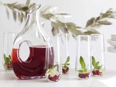 a pitcher and five glasses filled with liquid