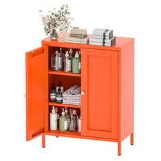 an orange cabinet with lots of bottles and soaps on it's shelf next to a vase filled with flowers