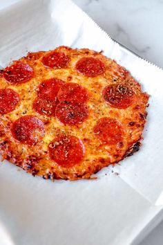 a pepperoni pizza sitting on top of a white paper