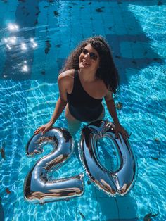 a woman is sitting in the water with an inflatable number twenty two balloon