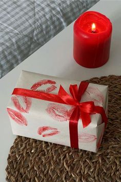 a wrapped present sitting next to a lit candle