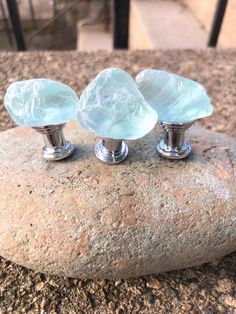 three glass knobs sitting on top of a rock