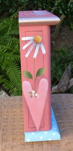 a pink wooden box with flowers painted on it