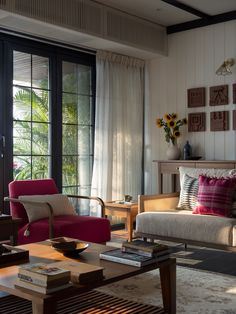 a living room filled with furniture next to a window covered in sun shining through the curtains