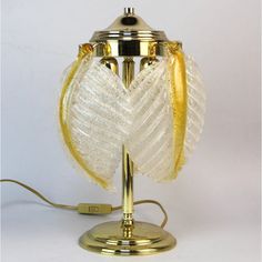 a lamp that is on top of a metal stand with a cord attached to it