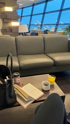 a living room with a couch, coffee table and large window overlooking the ocean is shown in this image