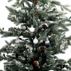 a christmas tree with ornaments hanging from it's branches and pine cones on the top