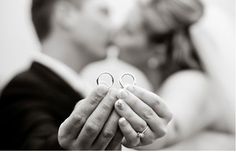 the bride and groom are holding their wedding rings in front of each other's face