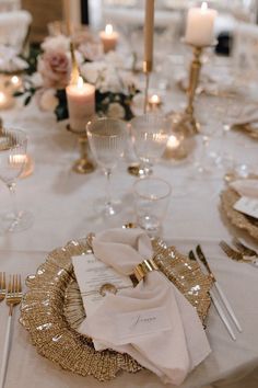 the table is set with white and gold plates, silverware, and napkins