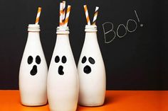 three white bowling pins with faces painted on them and two drinking straws in each