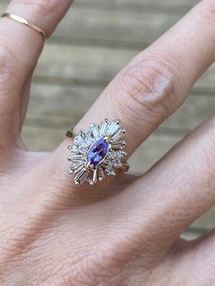 a woman's hand with a diamond and blue sapphire ring on top of her finger