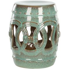 a green ceramic stool with an intricate design