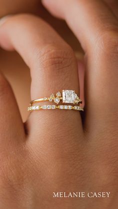 a woman's hand with a gold and white diamond ring on her left hand