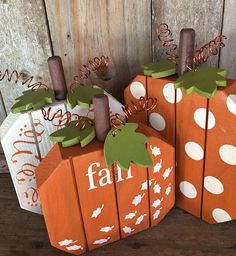 three wooden pumpkins with the word fall painted on them