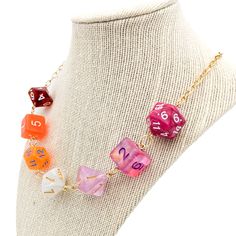 a close up of a necklace on a mannequin with different colored dices