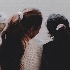 three girls standing next to each other with ponytails in their hair and one girl wearing a white shirt