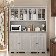 a kitchen area with a microwave, counter top and cabinets in grey wood finish colors