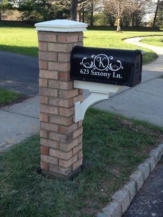 a brick mailbox sitting on the side of a road