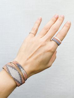 a woman's hand with three different bracelets on her wrist and the other arm