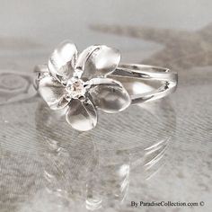 Sterling Silver 12MM Hawaiian Plumeria Ring with Clear CZ. The ring is made with sterling silver and rhodium finished to avoid tarnishing. It is set with a 12mm Hawaiian Plumeria Flower and clear CZ. Ring size 4-10 are available. Always appropriate and gorgeous, this ring is a timeless classic, and it belongs in every jewelry wardrobe. Nickel-free White Gold Anniversary Rings, Silver Cubic Zirconia Flower Ring, Silver Flower Ring With Cubic Zirconia, Silver Flower Shaped Cubic Zirconia Ring, Silver Cubic Zirconia Flower Ring Gift, White Sterling Silver Flower Ring With Brilliant Cut, White Brilliant Cut Sterling Silver Flower Ring, White Brilliant Cut Flower Ring In Sterling Silver, Silver Sterling Flower Ring With Brilliant Cut