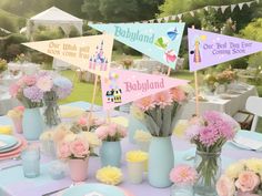 a table topped with vases filled with pink and yellow flowers next to tables covered in plates and napkins