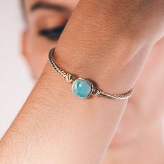 Indulge in the breathtaking beauty of nature with this exquisite larimar stone bracelet. Handcrafted with passion and attention to detail, featuring a smooth and polished 1cm larimar stone, this unique gemstone bracelet exudes a calming energy that will transport you to the turquoise waters of the tropics. These bracelets come in 2 sizes (Medium: 19 cm and Small: 17cm) The delicate, blue hues of the larimar stone are beautifully offset by the luxurious gold-plated bracelet, creating a stunning and timeless piece of jewelry that is sure to become a cherished favorite in your collection. The intricate design of the bracelet is a testament to the craftsmanship and skill of the artisan who created it, with each detail carefully considered to create a piece that is both elegant and striking. Bu Turquoise Larimar Cabochon Jewelry, Larimar Bracelet Jewelry Gift, Elegant Larimar Bracelet Jewelry, Elegant Turquoise Larimar Bracelets, Turquoise Larimar Natural Stone Bracelets, Turquoise Larimar Bracelet, Turquoise Larimar Bracelets As A Gift, Turquoise Larimar Bracelets For Gifts, Larimar Bracelet